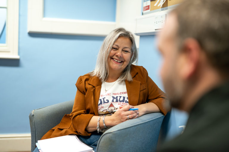 Stay team member smiling while talking to a man - Telford homeless charity